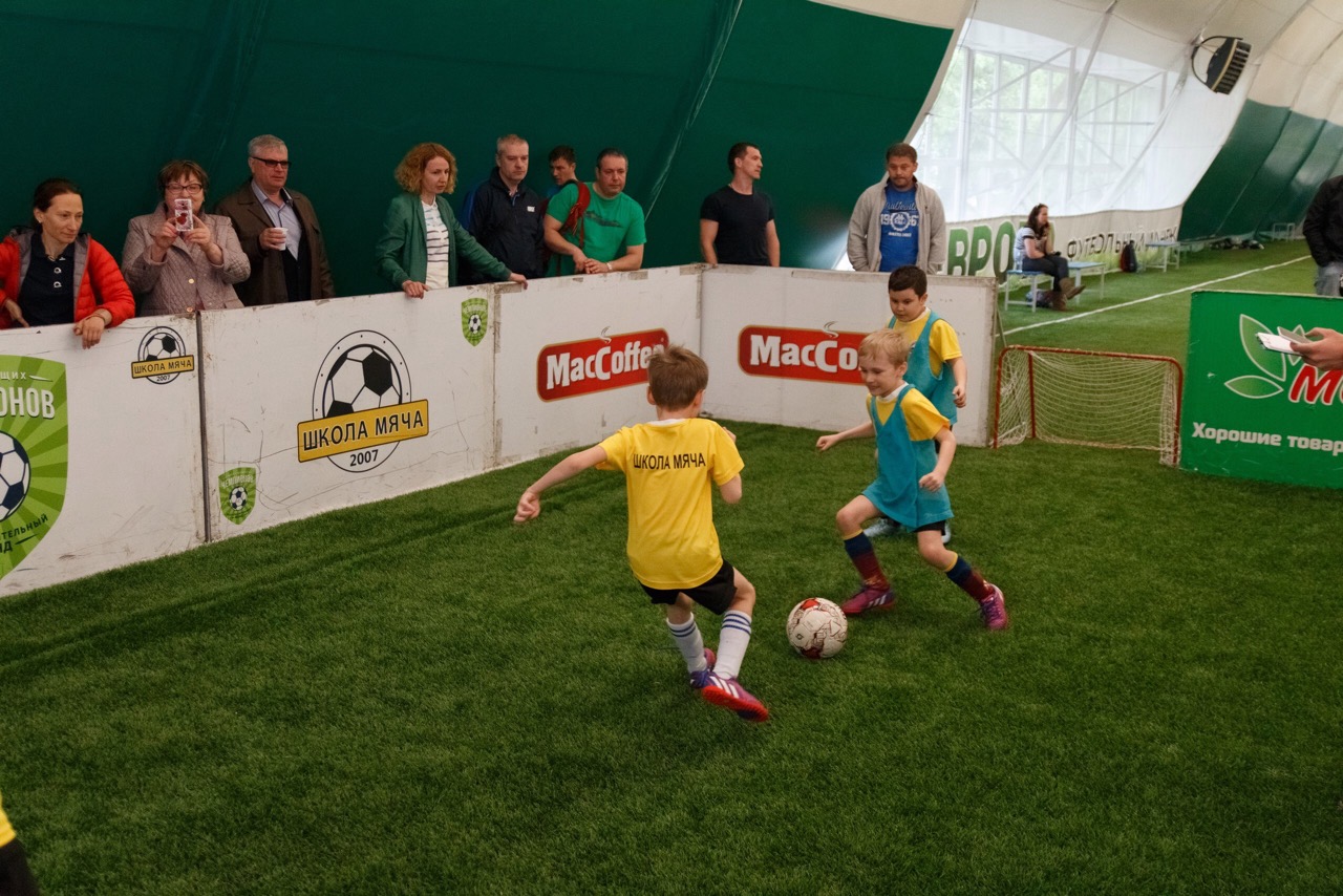 Дети 8-10 лет играют в футбол на соревнованиях на искусственном газоне