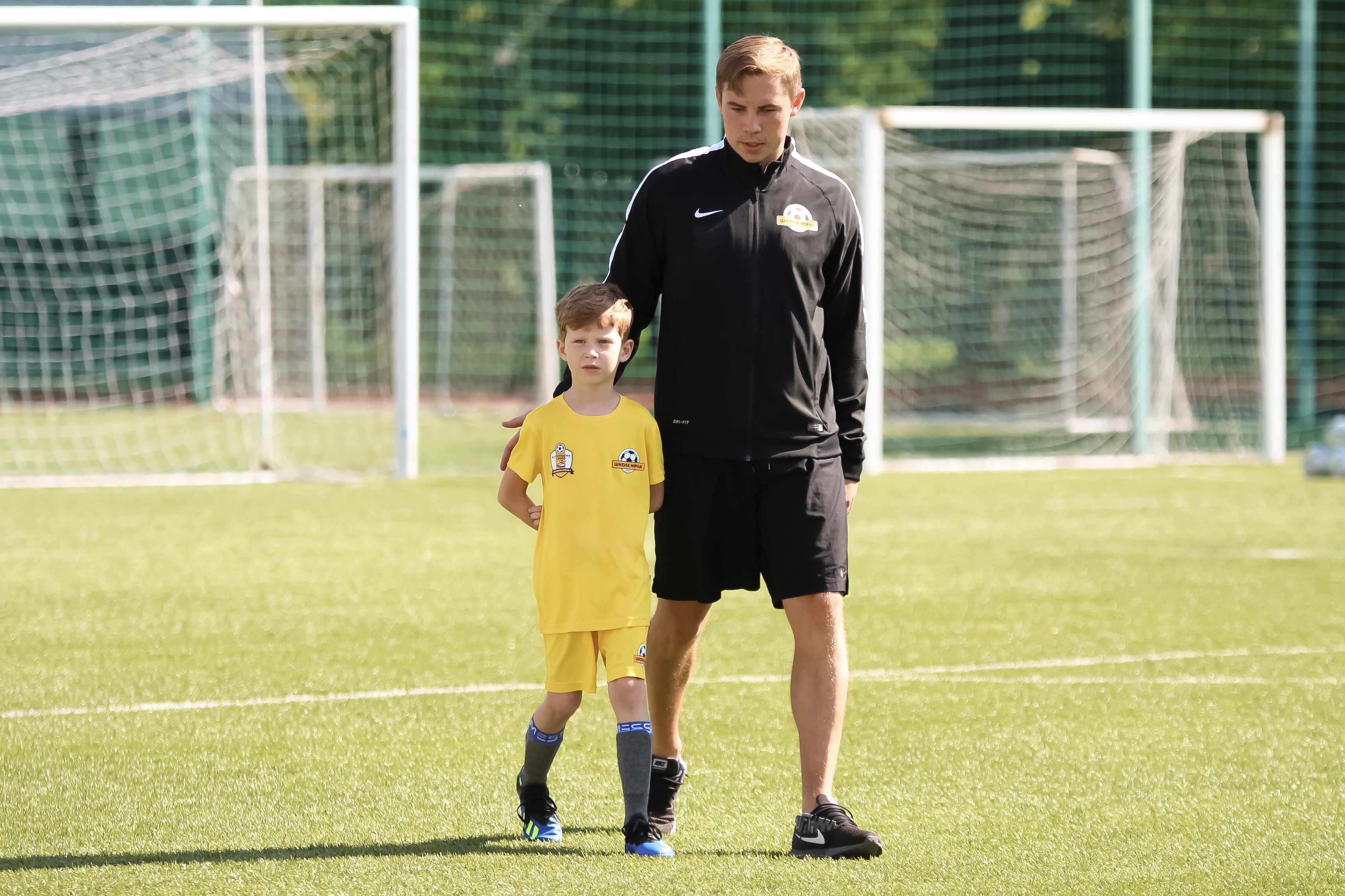 Тренер Школы мяча на открытом уроке с ребенком