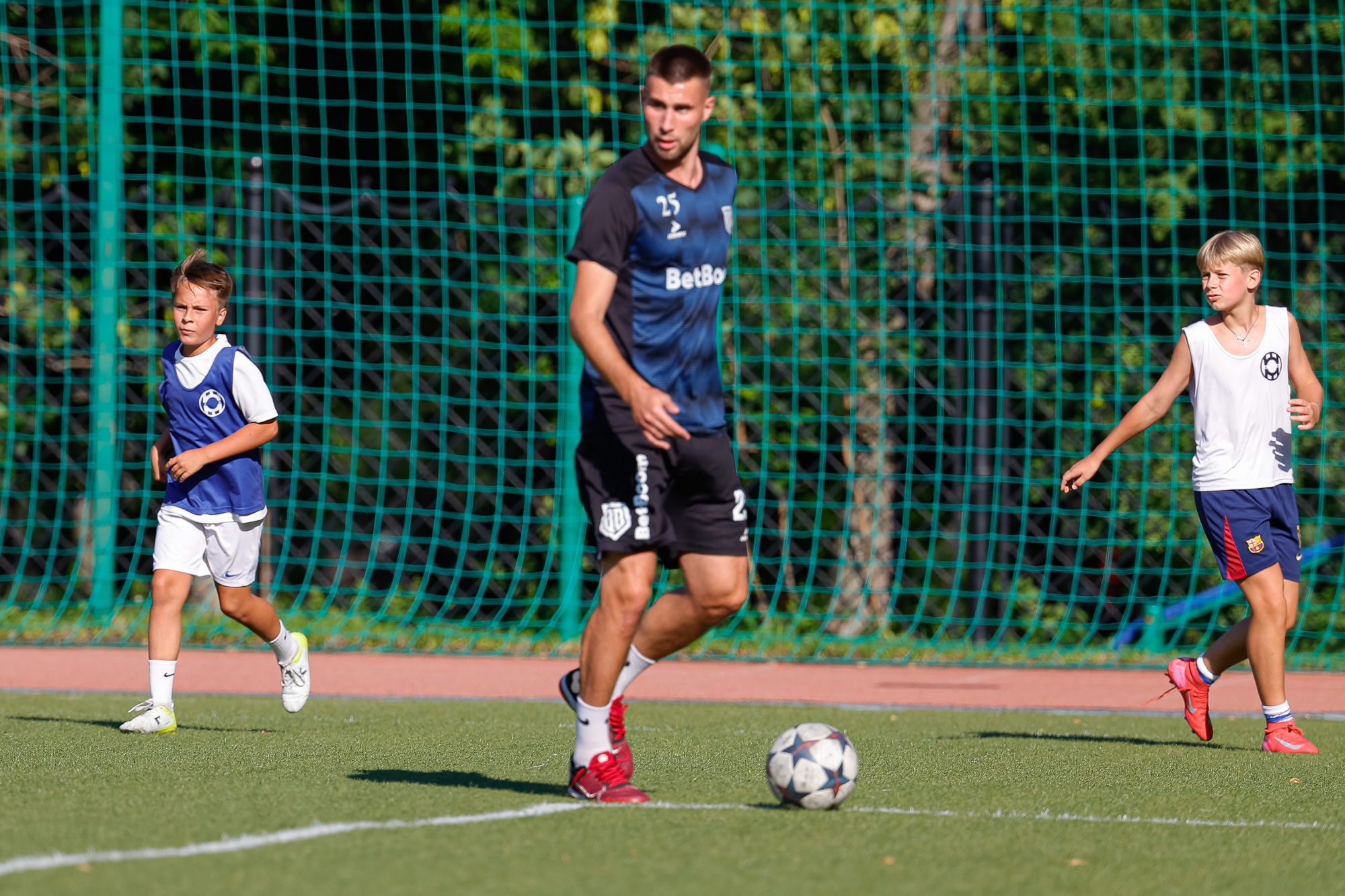 Футболисты футбольной школы для детей Школа мяча играют в футбол со звездой футбола