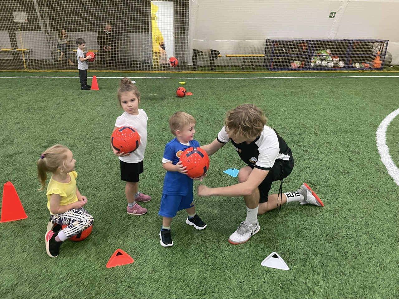 Тренер объясняет детям 4-5 лет футбольный элемент.jpeg Тренер объясняет детям 4-5 лет футбольный элемент
